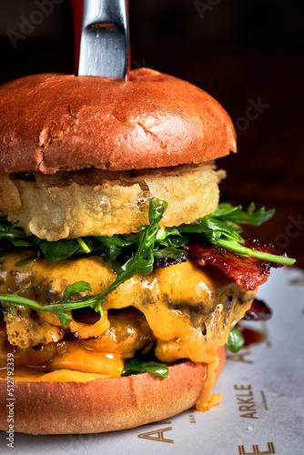 Summer double burger cut in two with cheese, tomato and vegetable.