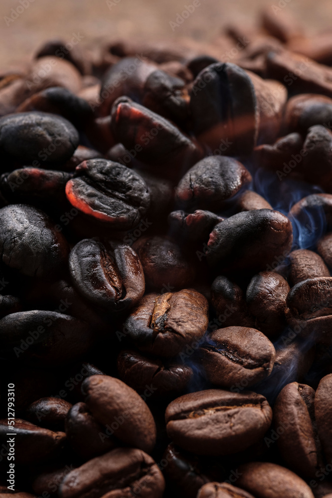 Obraz premium Roasted smoking coffee beans macro close up creative background