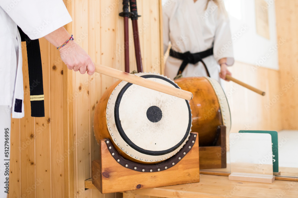 a person with a karate kimono or karategi, plays the Japanese drum a person with a karate kimono or karategi, plays the Japanese drum