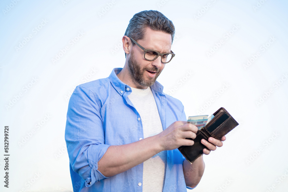 Serious guy in glasses taking cash money out of wallet sky background Serious guy in glasses taking cash money out of wallet sky background