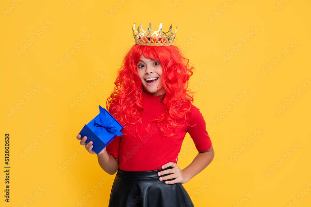 positive child in princess crown with present box on yellow background