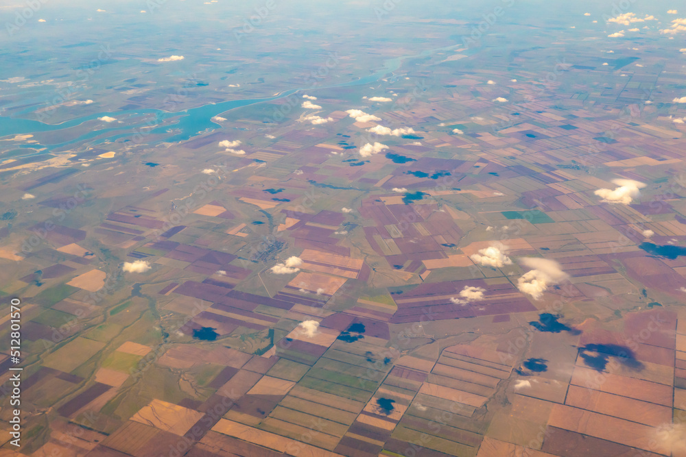 Aerial photo of Farmland . Agricultural Landscape. a pattern of round and rectangular compressed, plowed and green fields, covered with a lace of clouds. View from the plane High quality photo