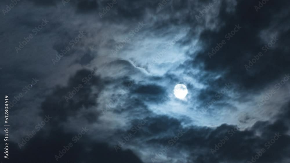 Full moon with moving black clouds. Nighttime timelapse. Clouds floating through the bright disk of the moon. Mysterious night scene Full moon with moving black clouds. Nighttime timelapse. Clouds floating through the bright disk of the moon. Mysterious night scene