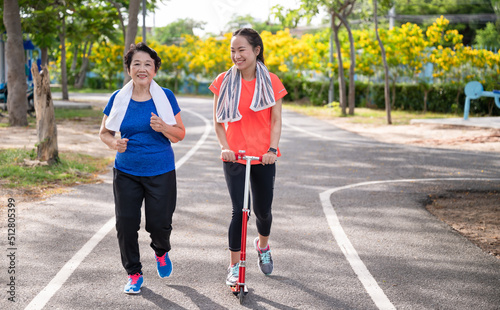 Asian senior mother and teenager daughter funny with exercise jogging at park
