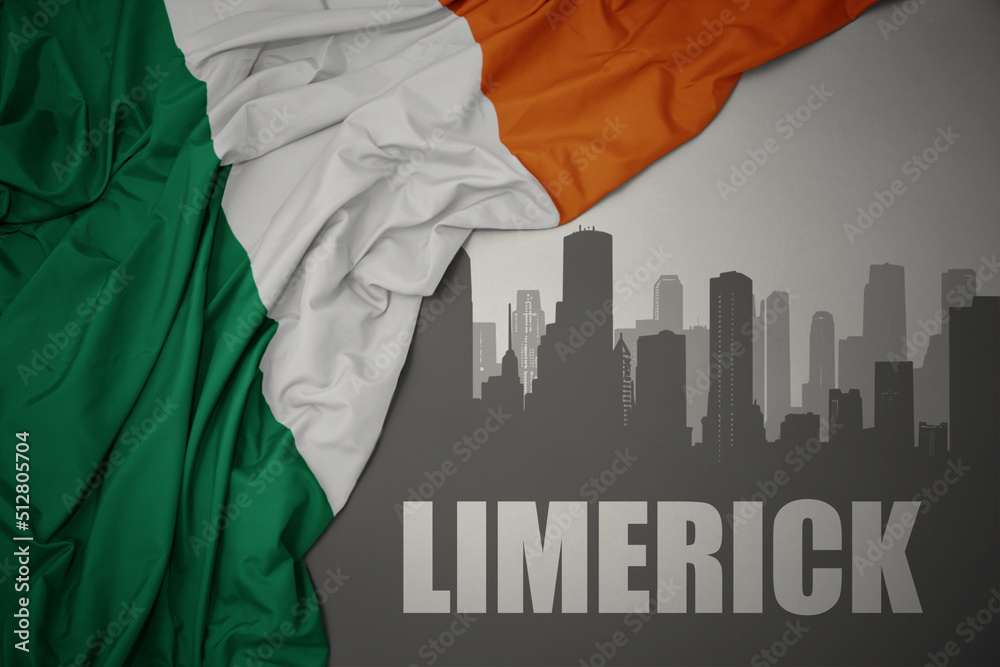 abstract silhouette of the city with text Limerick near waving national flag of ireland on a gray background.