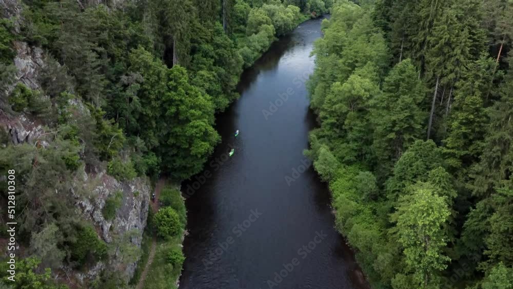 Aerial drone view of kayaking through river surrounded by forests. Aerial drone view of kayaking through river surrounded by forests.