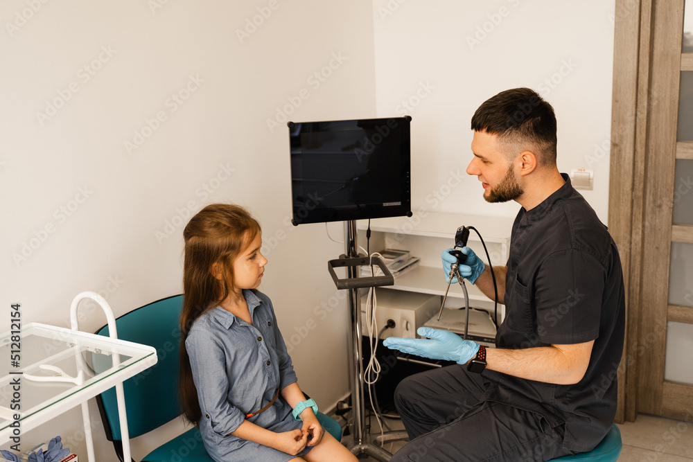 Rhinoscopy of child nose. Consultation with doctor. Children otolaryngologist calms child before procedure of rhinoscopy of nose. Rhinoscopy of child nose. Consultation with doctor. Children otolaryngologist calms child before procedure of rhinoscopy of nose.