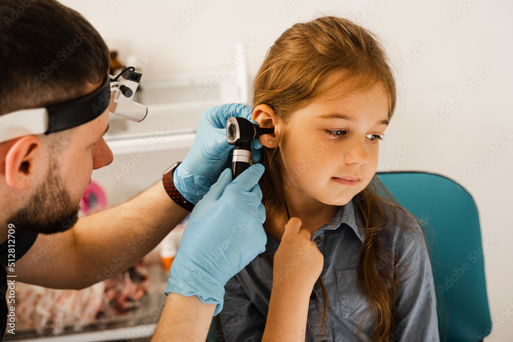 ENT doctor otolaryngologist looks through otoscope the ears of a little girl. Otoscopy. Treatment child ear pain. ENT doctor otolaryngologist looks through otoscope the ears of a little girl. Otoscopy. Treatment child ear pain.