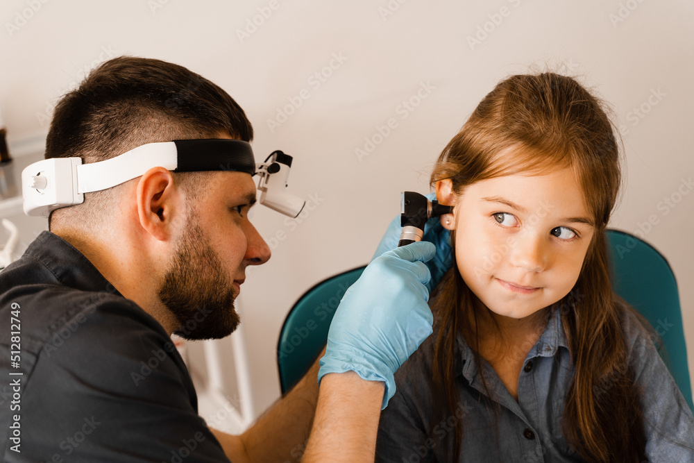 ENT doctor with otoscope. Otoscopy. Pediatrician otolaryngologist looks