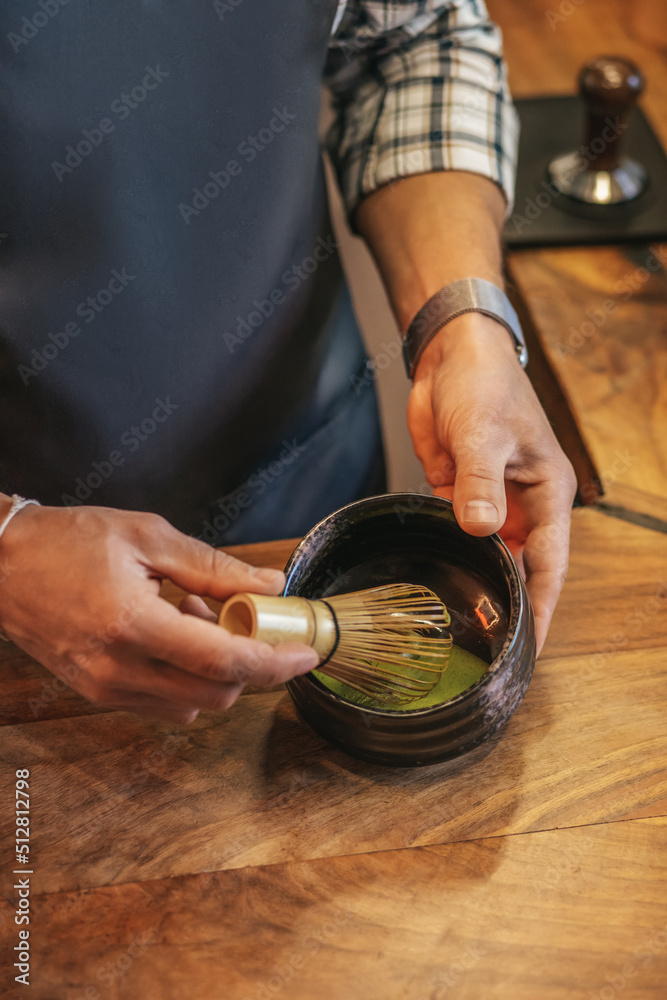 Mans hands churning liquid in round container