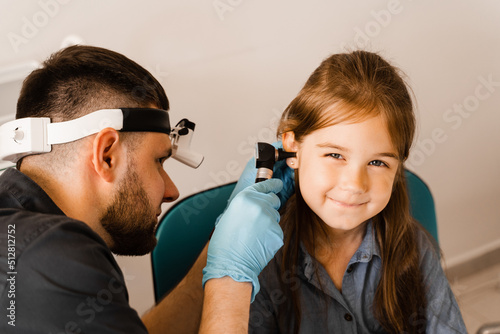 Otoscopy of child ears with otoscope. ENT doctor. Consultation with pediatric otolaryngologist. Treatment of childs ear pain. photo