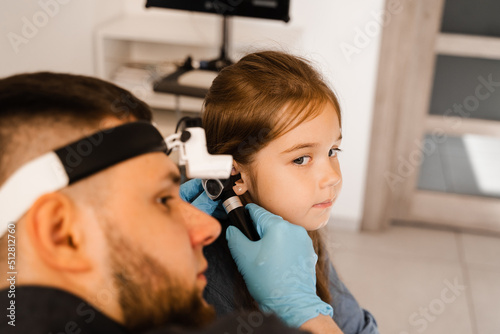 ENT doctor with otoscope. Otoscopy. Pediatrician otolaryngologist looks through otoscope the ears of child. Otoscopy. Treatment ear pain.