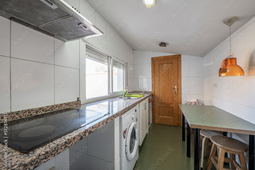 Kitchen of a house with sloping ceilings with green wooden table and pink granite countertop Kitchen of a house with sloping ceilings with green wooden table and pink granite countertop