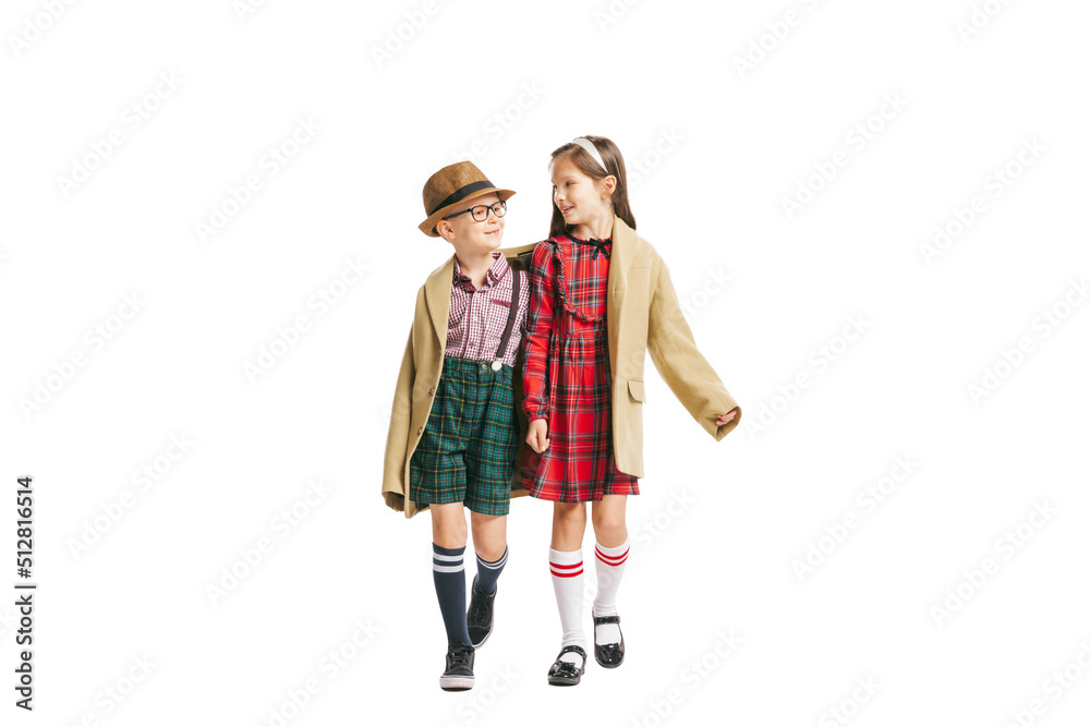 Portrait of little boy and girl, charming kids retro style outfit, fashion of 70s, 80s years isolated on white studio background with copy space for ad.