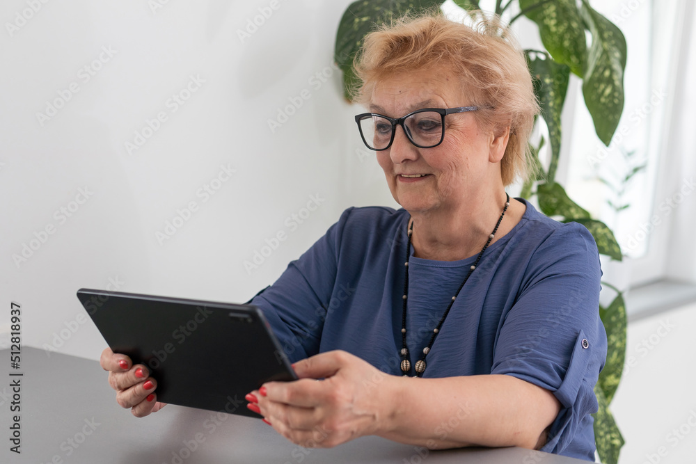 Senior woman making video call from tablet computer at home Senior woman making video call from tablet computer at home