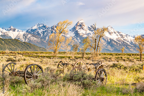 Old wooden wagons in a field near the Teton Mountains in Grand Teton National...