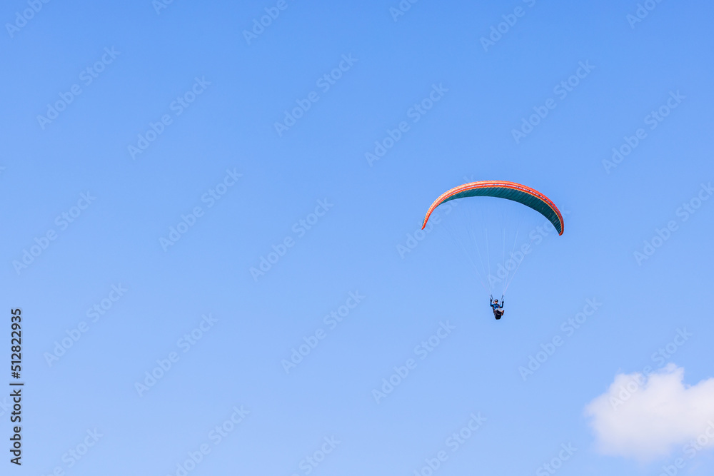 Paraglider flying high up at a blue sky Paraglider flying high up at a blue sky
