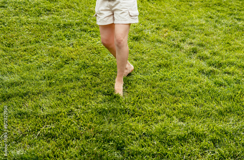 Woman feet barefoot closeup walking on green grass lawn Summer concept enjoying nature feeling