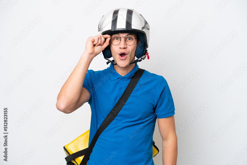 Young caucasian man with thermal backpack isolated on white background with glasses and surprised Young caucasian man with thermal backpack isolated on white background with glasses and surprised