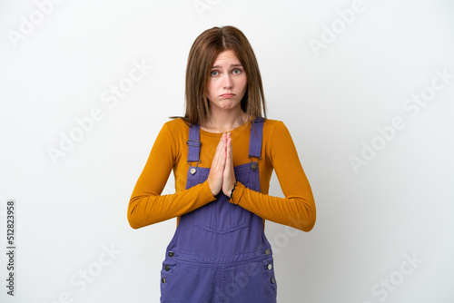 Young English woman isolated on white background keeps palm together. Person asks for something