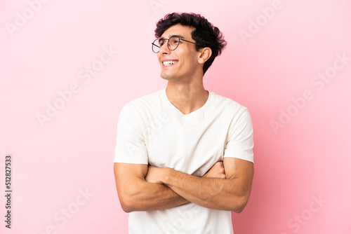Young Argentinian man isolated on pink background happy and smiling
