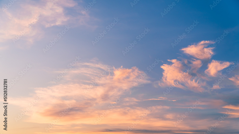 Evening sky with orange sunlight clouds on blue background