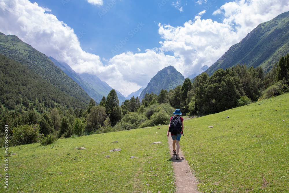 A woman hikes on a trail in the Tian Shan Mountains in Kyrgyzstan.