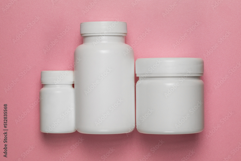 Three empty plastic jars on a pink background Three empty plastic jars on a pink background
