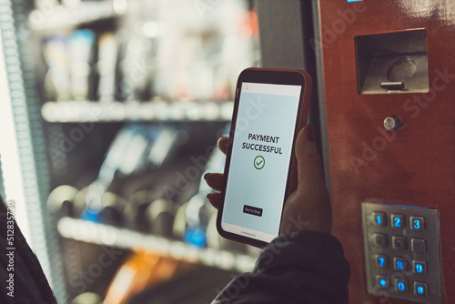 Foto Consumer paying for product at vending machine using contactless method of payment with mobile phone