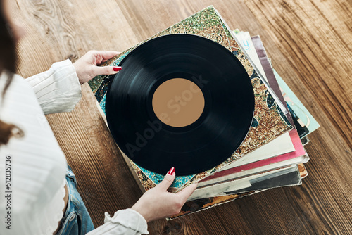 Playing vinyl records. Listening to music from vinyl record player. Retro and vintage music style. Woman holding analog LP record album. Music passion