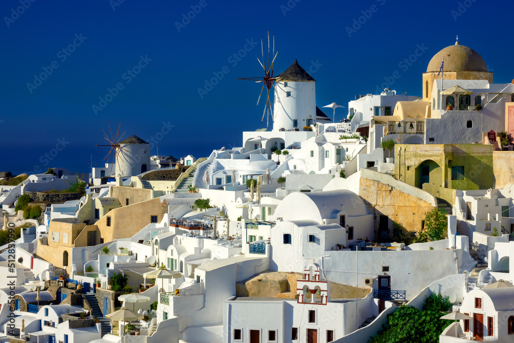 Famous windmills and cityscape of Oia town on Santorini island in Greece. Traditional white houses. Greece, Aegean Sea. Popular European