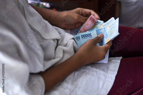 Close-up of kid counts the money given by his family during lebaran idul fitri day known as THR. 