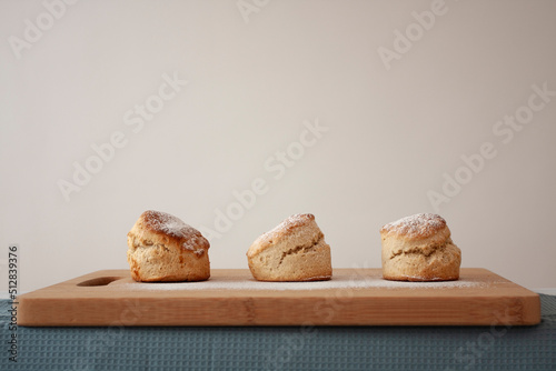  Scones - home made sweet scones on the bread board, side view on the white background 