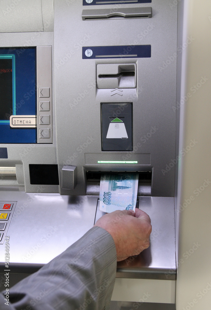 hand inserting banknote into cash dispense hand inserting banknote into cash dispense