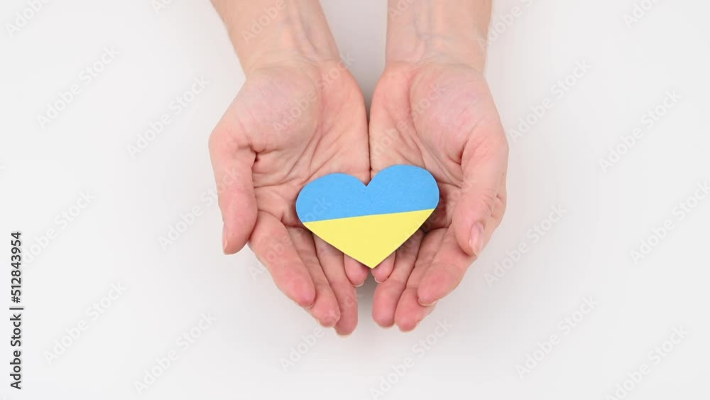 Woman opens her palms with a heart with the flag of Ukraine. Woman opens her palms with a heart with the flag of Ukraine.