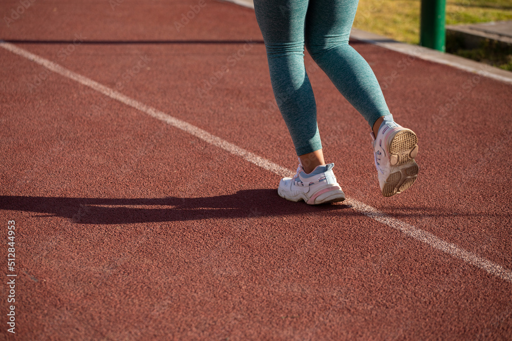 Detalle de pies de mujer corriendo en una pista atlética. Concepto de deportes y gente. Detalle de pies de mujer corriendo en una pista atlética. Concepto de deportes y gente.