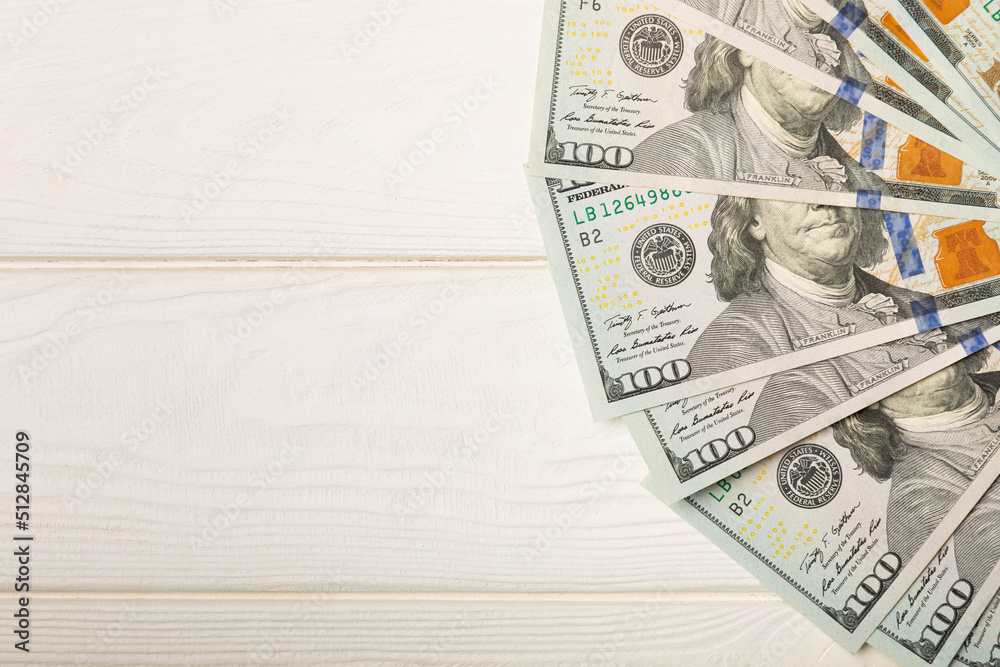 Money, US hundred dollar bills background on white wooden background. Money is scattered on the table. Finance and economics concepts.Money accumulation concept.Currency saving.Investment.Copy space. Money, US hundred dollar bills background on white wooden background. Money is scattered on the table. Finance and economics concepts.Money accumulation concept.Currency saving.Investment.Copy space.