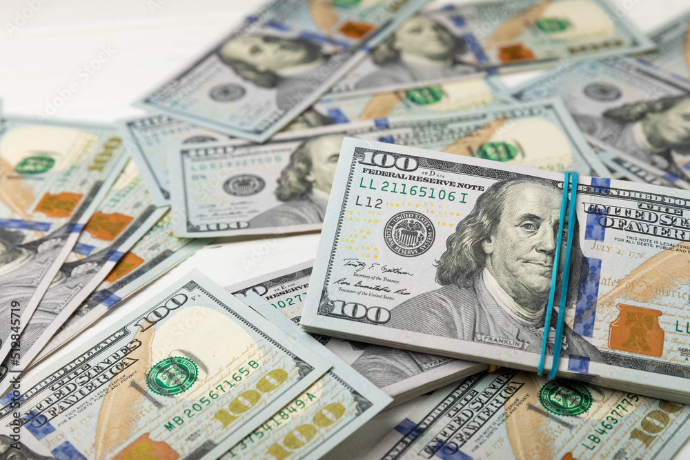 Money, US hundred dollar bills background on white wooden background. Money is scattered on the table. Finance and economics concepts.Money accumulation concept.Currency saving.Investment.Copy space. Money, US hundred dollar bills background on white wooden background. Money is scattered on the table. Finance and economics concepts.Money accumulation concept.Currency saving.Investment.Copy space.