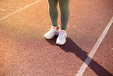 close up de pies de deportista en una pista atlética al atardecer. Concepto de personas y estilo de vida.