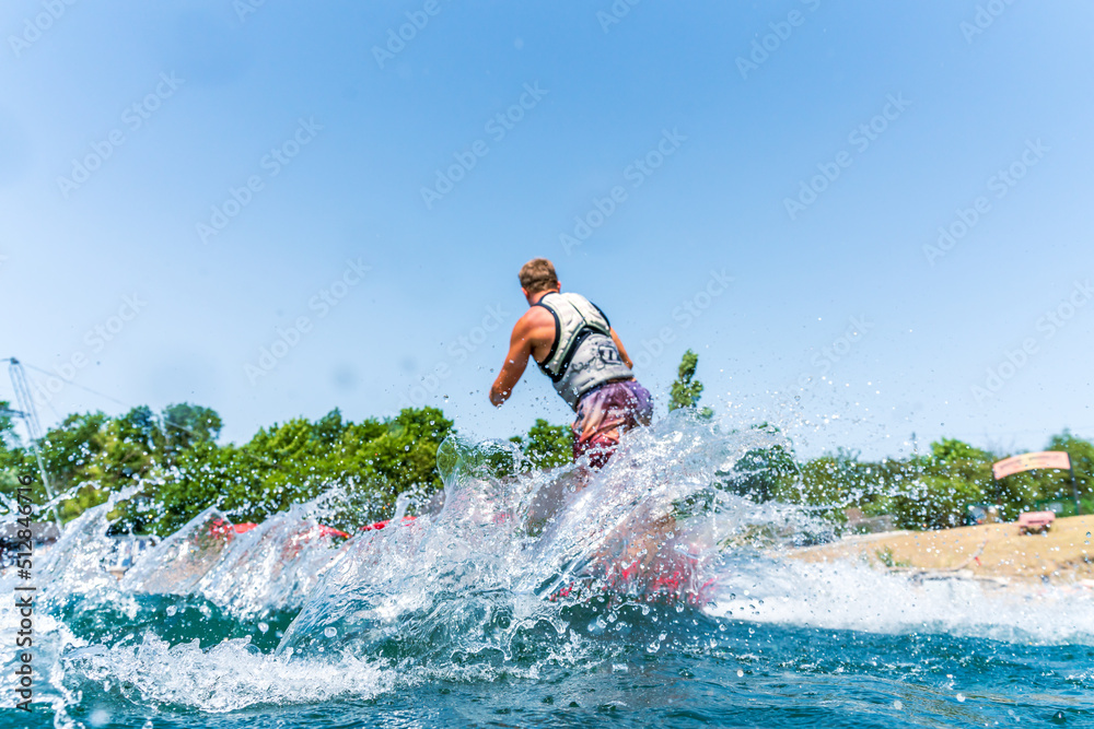 Splashing water because of a wakeboarder in background Splashing water because of a wakeboarder in background