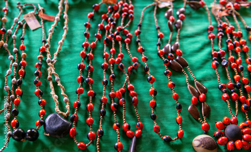 Organic handicrafts from the Amazon rainforest with huayruro seeds (Ormosia coccinea) necklaces, Yasuni national park, Ecuador. photo