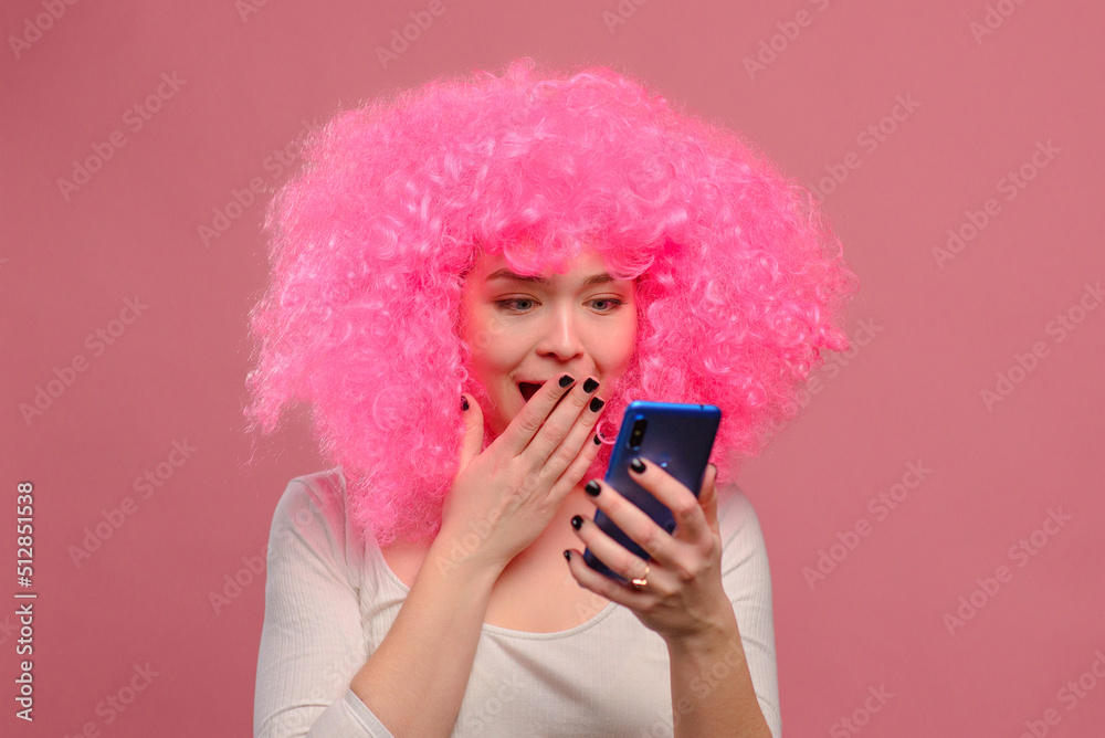 Smiling young pink haired woman dancing on pink background. Smiling young pink haired woman dancing on pink background.