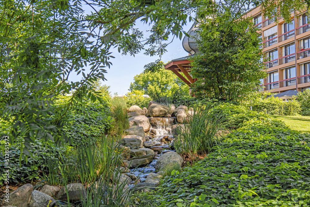 A small waterfall among large stones and green trees. A small waterfall among large stones and green trees.