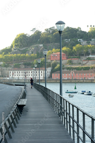 A woman is running along the river on a wooden path