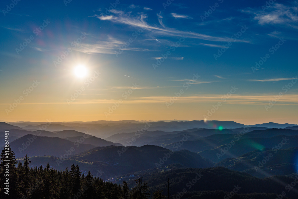 Mountain valley with mountain ranges sheltered by dark forests in Rhodope Mountains against the backdrop of sunny sky