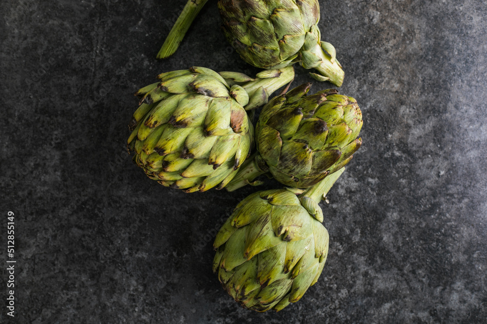 Obraz premium Fresh Artichoke on black background. Raw Artichok closeup