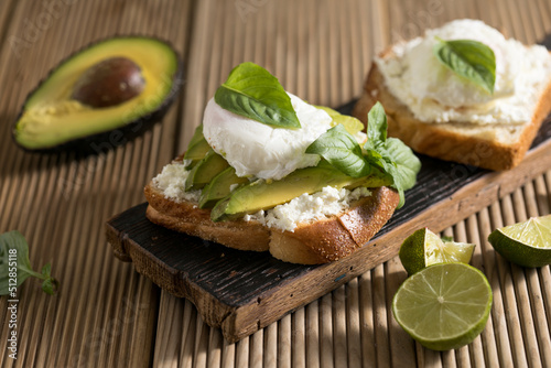 Breakfast concept - toast bread with sliced avocado, pouched egg photo