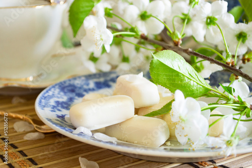Set of white chocolate candies, tenderness of morning coffee, with white cherry flowers