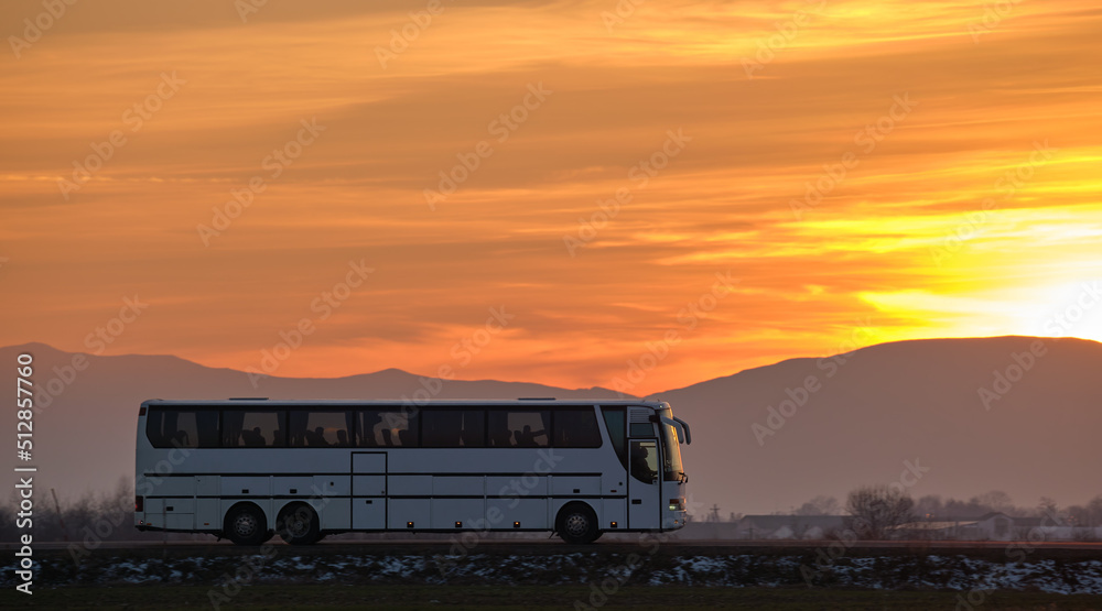 Intercity passenger bus driving on highway road in evening Intercity passenger bus driving on highway road in evening