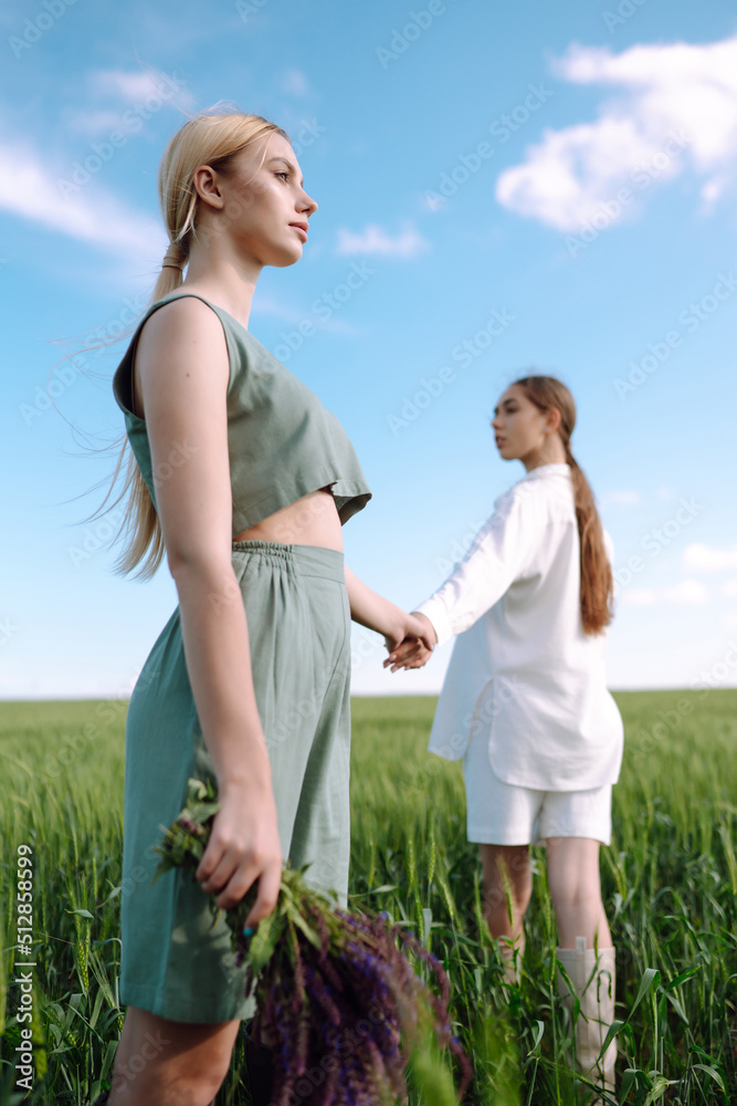 Two fashion woman in the green field. Freedom travel. Summer landscape.